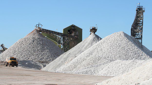Aggregate stockpiles and conveyors at a quarry processing plant